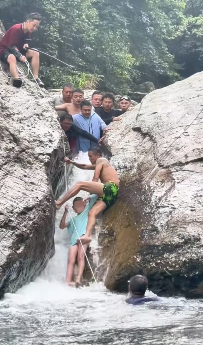 Khoảng khắc nhóm du khách giải cứu thành công bé trai bị mắc kẹt ở khe suối tỉnh Quý Châu, hôm 24/8. Ảnh: New.qq
