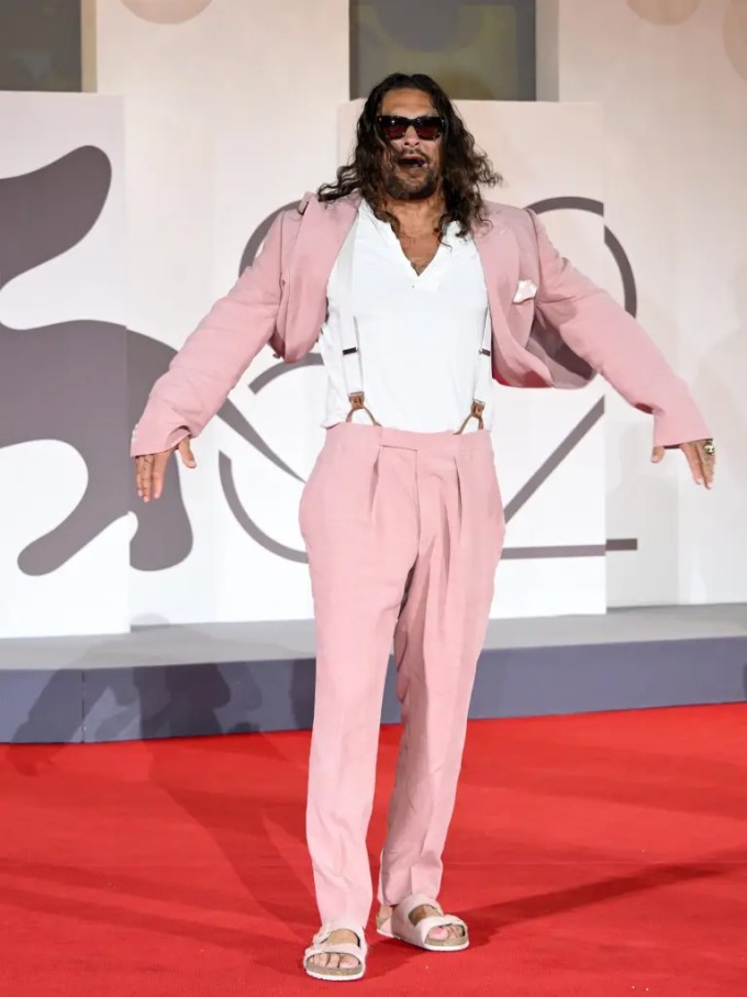 Jason Momoa nổi tiếng là người yêu thích trang phục 'màu hường' và phong cách phóng khoáng. Anh từng đưa dấu ấn thời trang riêng của mình vào nhân vật phản diện Dante Reyes trong phim 'Fast X'. Tuy nhiên đây là lần đầu tiên Momoa xỏ dép hồng lên thảm đỏ.