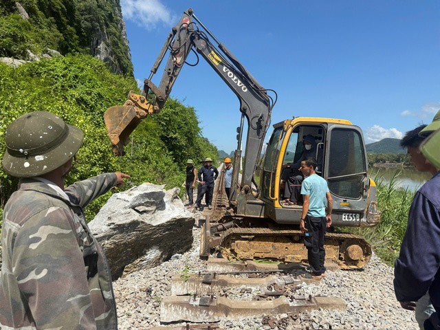 Công nhân đường sắt dùng máy móc chuyên dụng xử lý đá sạt lở trên đường ray sáng 4-9 gần ga Lạc Sơn, Quảng Trị.