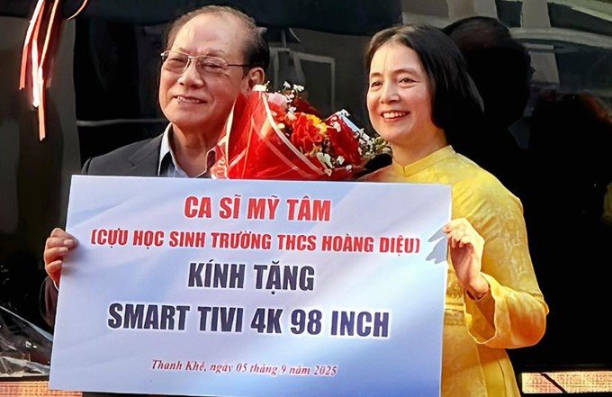 Bố của ca sĩ Mỹ Tâm (trái) thay con gái trao quà cho đại diện trường THCS Hoàng Diệu. Ảnh: Nhân vật cung cấp