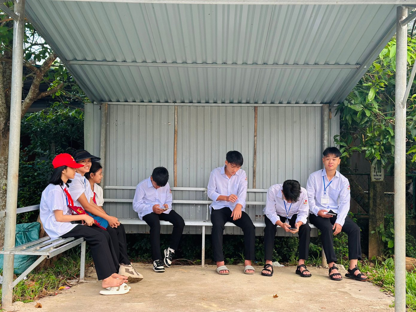 Nhiều học sinh Trường THPT Hàm Nghi (Hà Tĩnh) ngồi chờ xe buýt để đến trường khai giảng năm học mới.