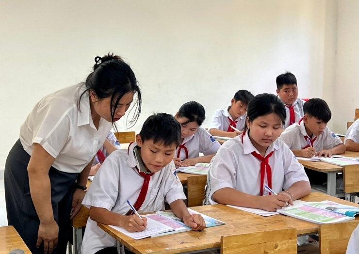 Cô giáo đến từng bàn học dõi theo cách viết bài của từng học sinh, hướng dẫn các em cách ghi chép sao cho hiệu quả.