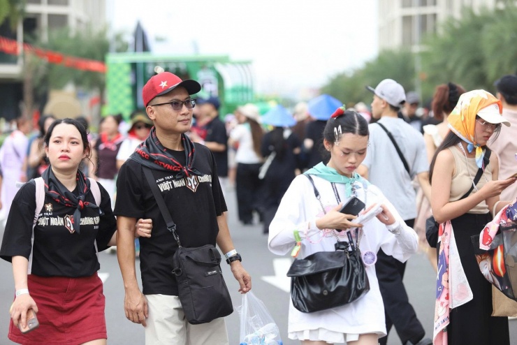 Càng về chiều dòng người càng đông. Nhiều fan mang theo khăn choàng, mặc áo mang logo chương trình và phụ kiện để cổ vũ thần tượng.