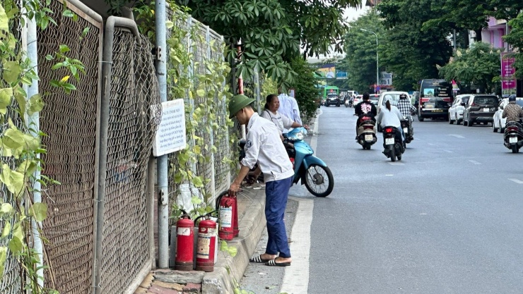 Nhân viên Công ty TNHH MTV Khai thác điểm đỗ xe Hà Nội dọn dẹp, khóa hàng rào sắt bằng dây thép.
