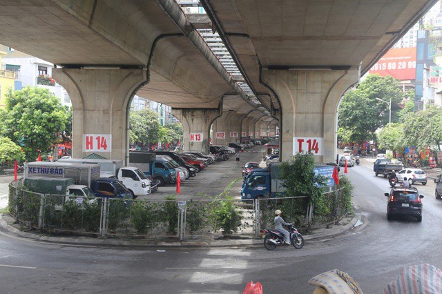 Trước thời điểm vụ cháy xảy ra, có nhiều bãi giữ xe dưới gầm cầu Vĩnh Tuy đều được quây kín bằng hàng rào lưới sắt, bên ngoài có cắm biển thể hiện đơn vị được cấp phép trông giữ xe là Công ty TNHH Khai thác điểm đỗ xe Hà Nội. Ảnh: Nguyễn Tường