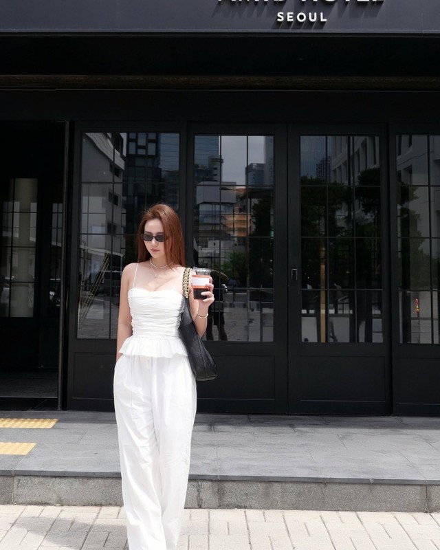 Công thức áo hai dây peplum và quần trắng ống suông tạo nên tổng thể outfit nữ tính cho hot girl Huyền Lizzie. Nhờ tông màu trắng làm chủ đạo, outfit còn mang đến cho người diện sự trẻ trung.
