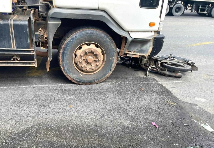 Chiếc xe máy bị mắc kẹt dưới gầm ô tô tải ben