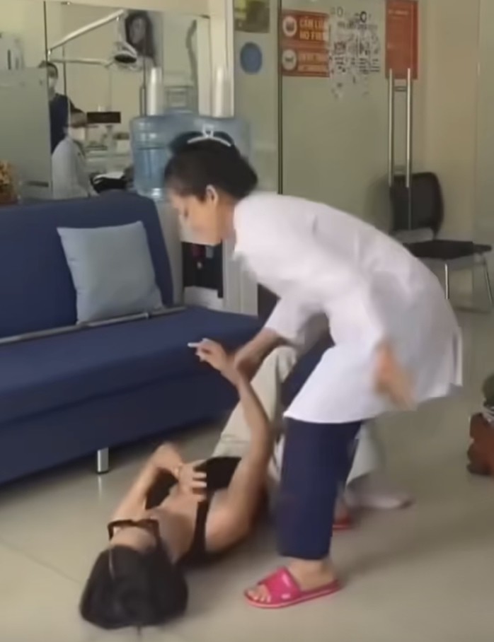 Khách bị người phụ nữ mặc áo blouse kéo ngã từ trên ghế sofa xuống sàn nhà. Ảnh cắt từ clip