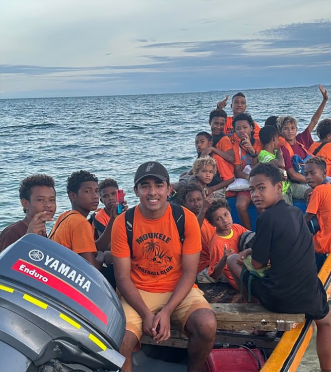 Arjun Malaviya (đội mũ) ngồi thuyền trong chuyến đi đến Papua New Guinea. Ảnh: DM