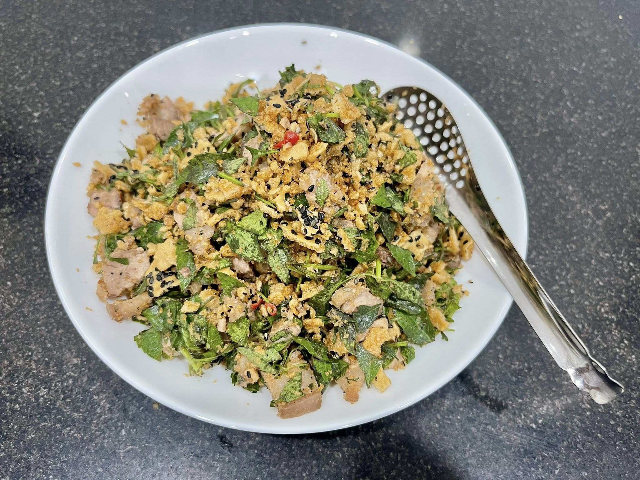 Sau cùng trộn thịt với bánh đa giã dập, thêm chút ớt cay. Món nộm ba chỉ với rau giậu rách đậm đà, thơm nức ăn cùng cơm nóng hoặc làm mồi nhậu đều siêu "cuốn".