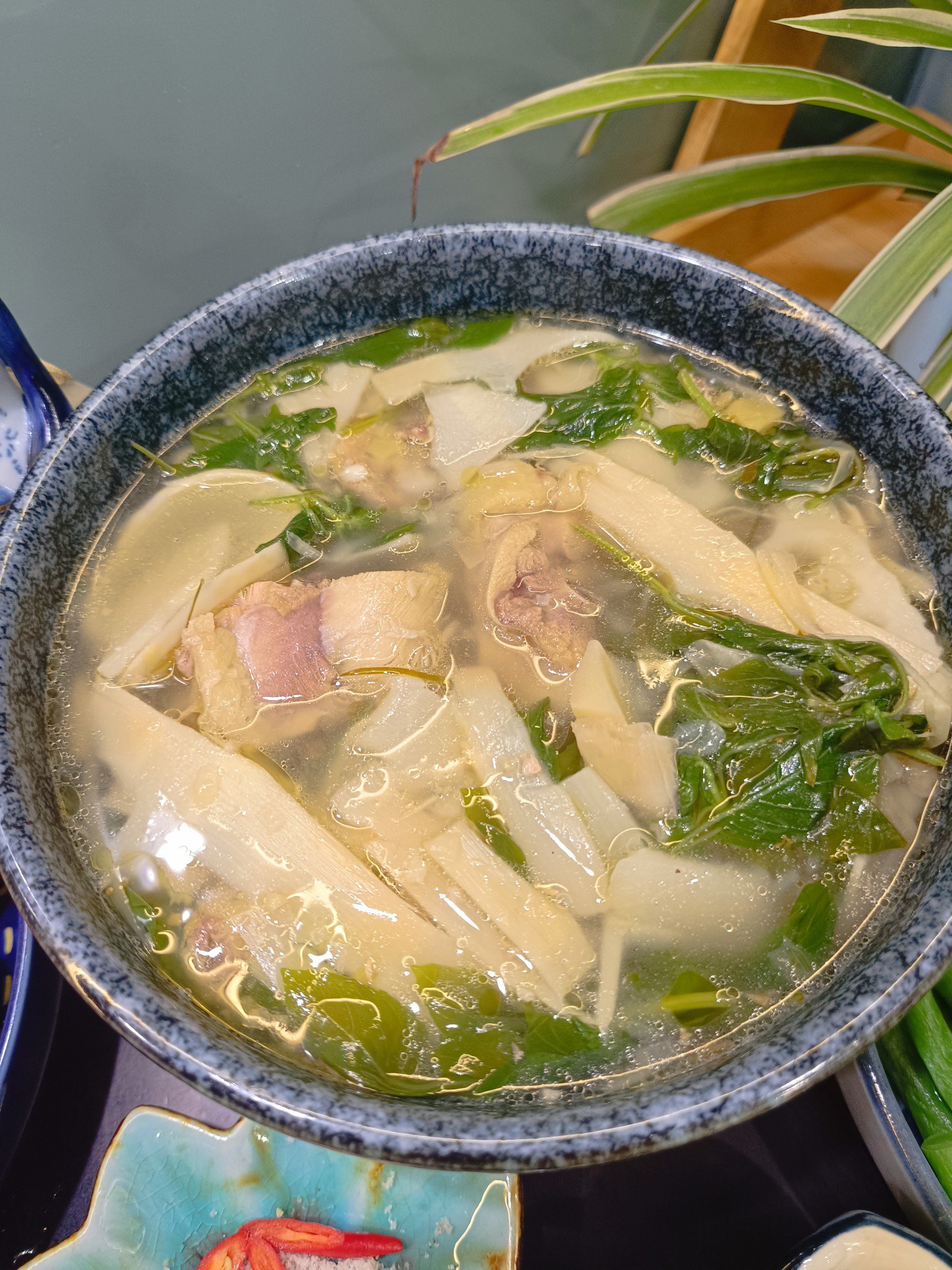 Múc canh gà măng chua lá é ra tô, vắt thêm chút nước chanh cho tăng hương vị hấp dẫn của món ăn.