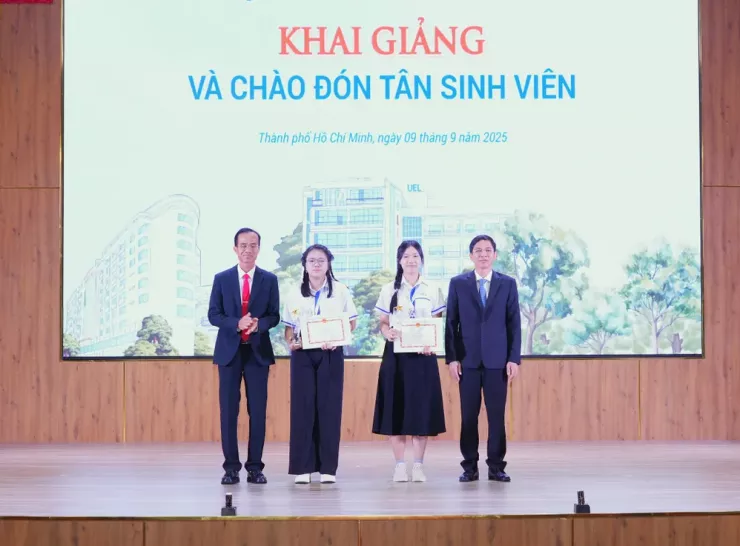 Hai tân sinh viên có thành tích cao nhất nhận khen thưởng từ lãnh đạo trường. Ảnh: THU TRANG