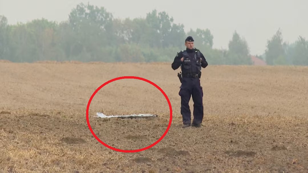 Cảnh sát Ba Lan đứng cạnh mảnh vỡ một chiếc UAV bị bắn hạ (ảnh: Reuters)