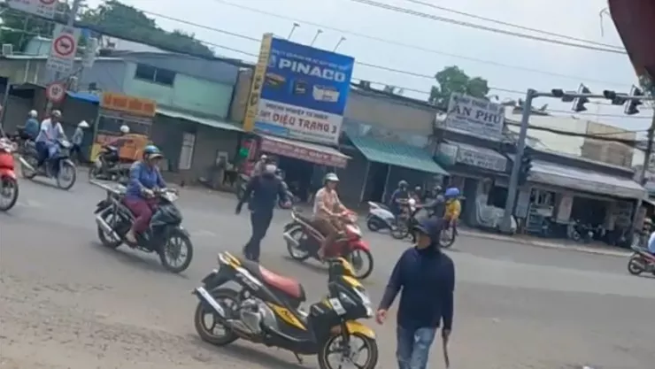 Người đàn ông biểu hiện bất thường, tay cầm rựa đi vào bốt chỉ huy giao thông ở giao lộ. Ảnh cắt từ clip