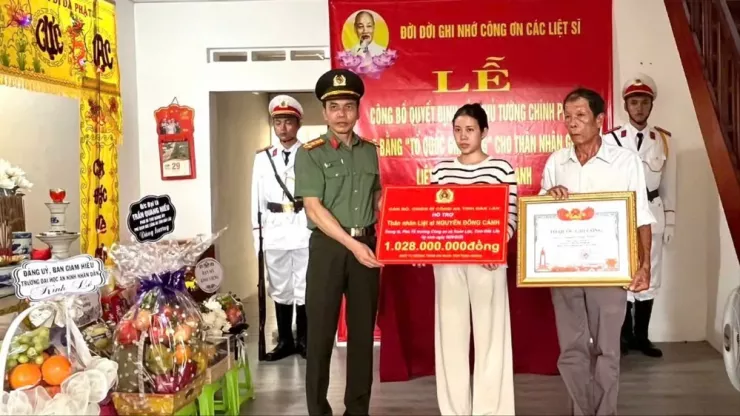 Đại tá Trần Quang Hiếu, Phó Giám đốc Công an tỉnh Đắk Lắk trao Bằng Tổ quốc ghi công cho liệt sỹ Nguyễn Đông Cánh; trao hơn 1 tỉ đồng ủng hộ gia đình thân nhân liệt sỹ. Ảnh: S.Đ