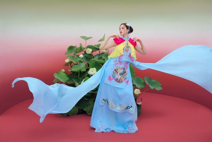 Trần Tiểu Vy gây chú ý khi mới đăng tải bộ ảnh diện áo yếm cách điệu giữa không gian được phủ bởi hình ảnh hoa sen. Các thiết kế sử dụng bảng màu rực rỡ từ hồng fuchsia, xanh cobalt, lam ngọc đến vàng chanh.