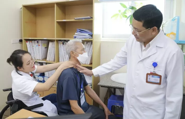 Một nữ bác sĩ nội trú cùng GS.TS Lê Văn Quảng, Giám đốc Bệnh viện K, đang thăm khám cho bệnh nhân. Ảnh: BVCC
