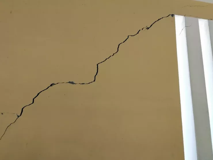 Vách tường điểm chính gần đó bị nứt toác nguy hiểm trong khi ngôi trường mới xây lại bỏ hoang. Ảnh PN.