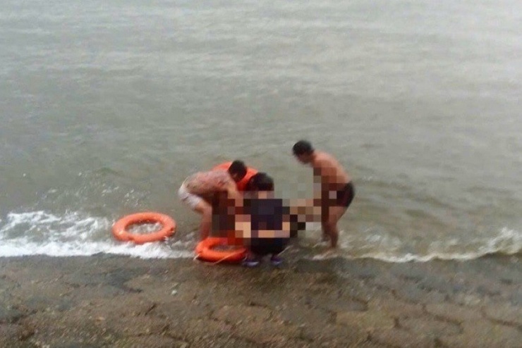 Nạn nhân được đưa vào bờ sơ cứu nhưng không qua khỏi. Ảnh: Phạm Duy.