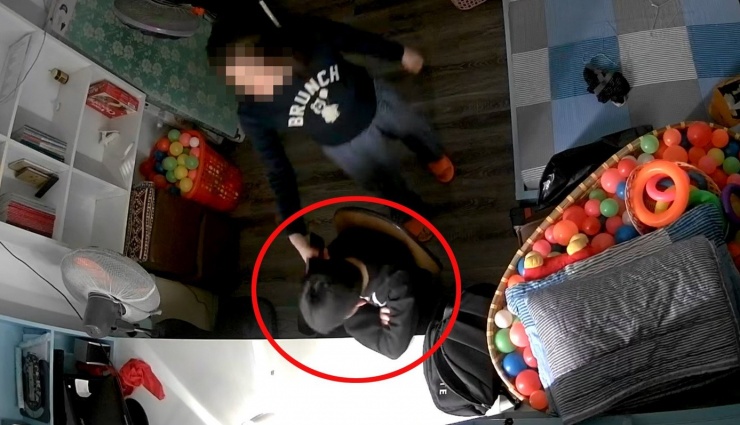 Hình ảnh người phụ nữ cầm điện thoại đánh vào đầu bé trai. Ảnh cắt từ video.