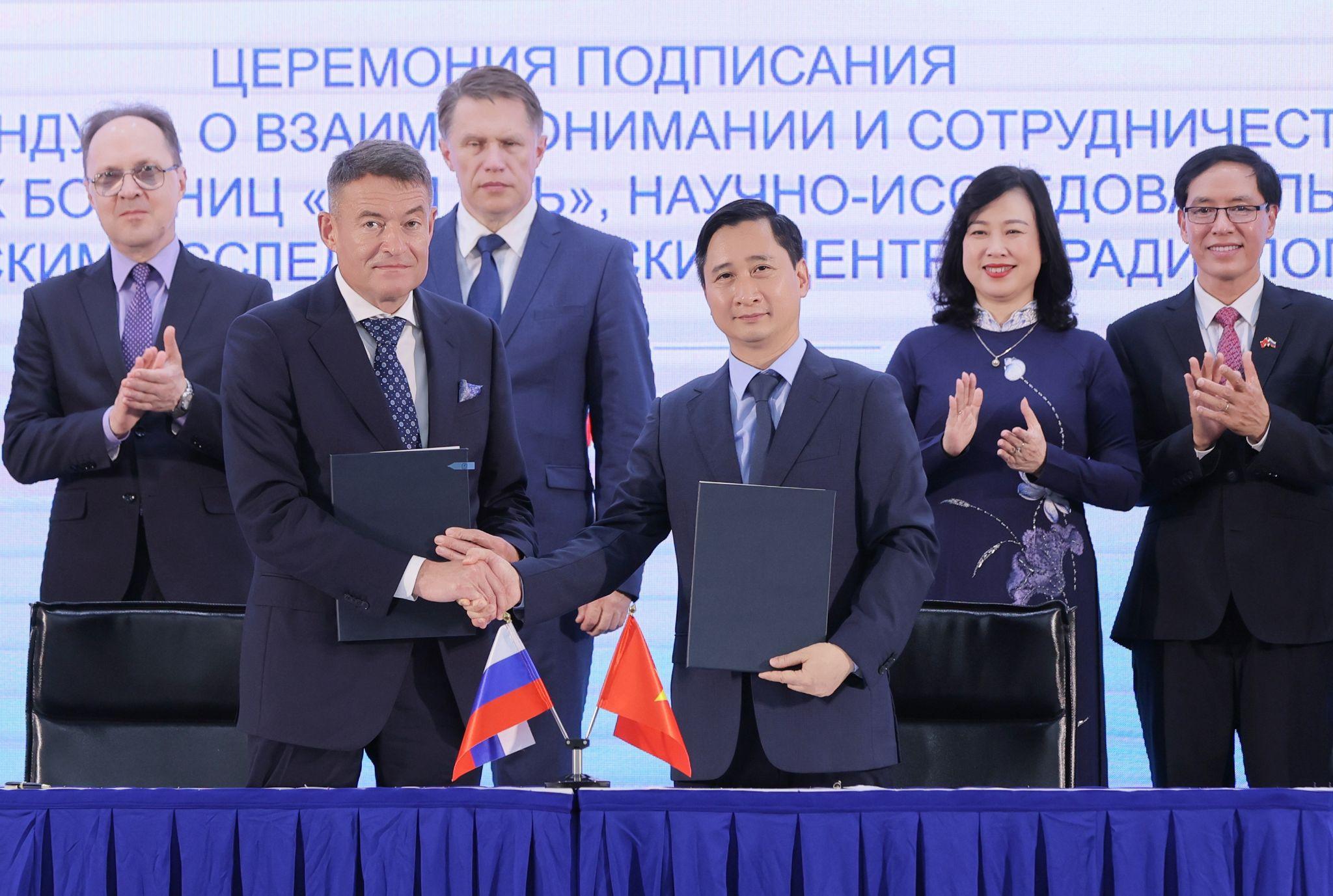 Ông Kaprin Andrey Dmitrievich - Tổng giám đốc Trung tâm Y học Quốc gia về Xạ trị - Viện Hertsen Liên bang Nga trao đổi văn kiện hợp tác với ông Ngô Chí Dũng, Chủ tịch HĐQT Hệ thống BVĐK Tâm Anh và Viện Nghiên cứu Tâm Anh (TAMRI) tại lễ ký kết chiều 12/9, với sự chứng kiến của Bộ trưởng Bộ Y tế Liên bang Nga Mikhail Albertovich Murashko và Bộ trưởng Bộ Y tế Đào Hồng Lan. Ảnh: BVĐK Tâm Anh