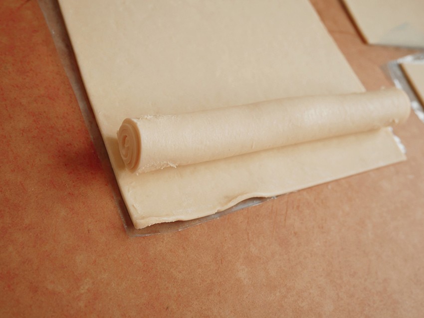 Bột ngàn lớp cuộn 2 lớp lại, cắt thành 3 phần bằng nhau. Cán mỏng, để phần rìa mỏng hơn để khi gói không bị dày.