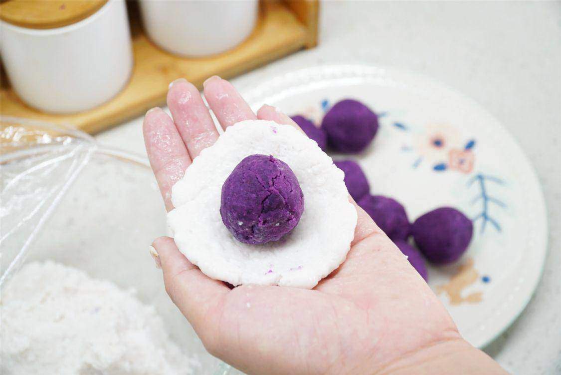 Đặt viên khoai tím vào giữa, bọc kín bằng vỏ trân châu, vê tròn lại. Bột báng khá dính tay, nên xịt một ít nước lên tay trước khi vo để dễ làm.