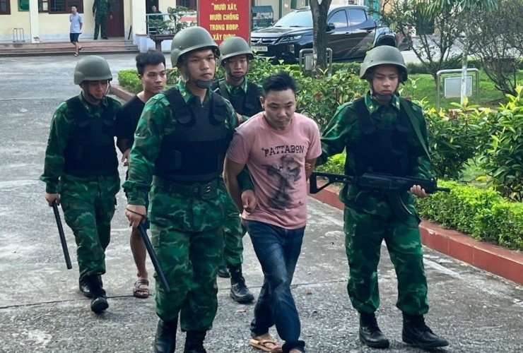 Lực lượng Biên phòng Lào Cai áp giải các đối tượng phạm tội đưa người nhập cảnh trái phép. Ảnh: Trung Dũng.