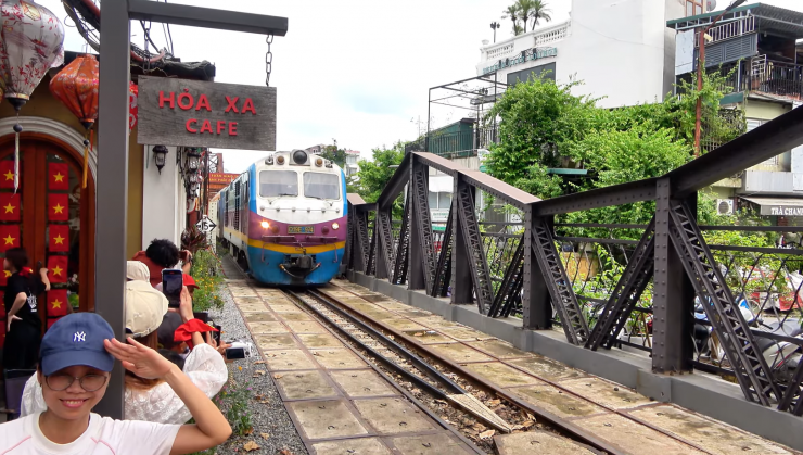 Du khách tranh thủ chụp ảnh check-in ở ga Long Biên trước khi lên chuyến tàu Hoa phượng đỏ về Hải Phòng