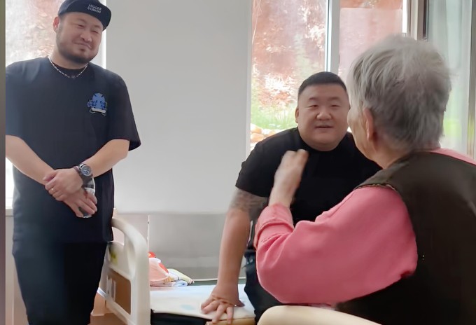 A Kai (ngồi giường) và cộng sự đang đến thăm hỏi một cụ bà ở Đại Liên, Trung Quốc tháng 9/2025. Ảnh: QQ