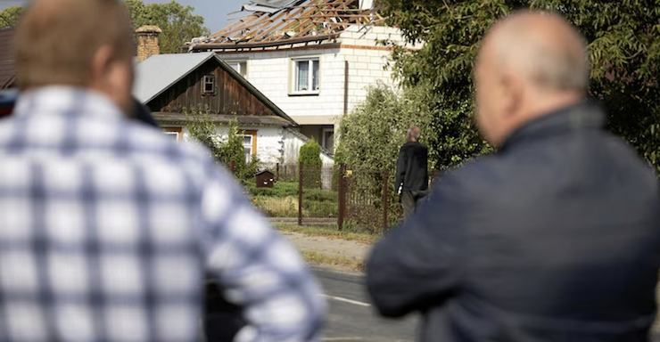 Người dân địa phương đứng từ xa quan sát thiệt hại. Ảnh: Reuters.