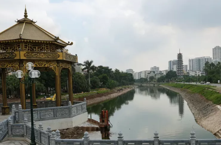 Đập dâng có kiến trúc cổ kính, hoà mình với dòng sông xanh ngắt, phía xa xa là toà tháp cao của chùa Bằng.