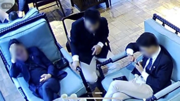 Người đàn ông ở giữa trực tiếp hành hung nam nhân viên của quán cà phê. Ảnh cắt từ clip