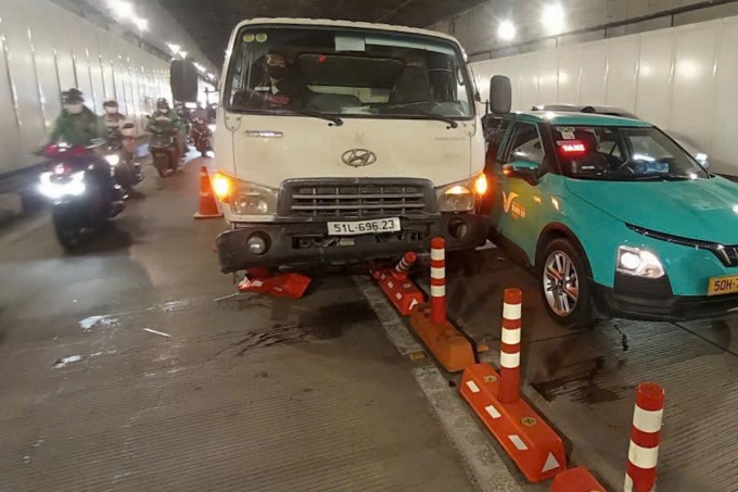 Các xe tông liên hoàn cán qua dải phân cách làn đường ôtô và xe máy, chắn ngang đường khiến giao thông bị ách tắc. Ảnh: Minh Bằng