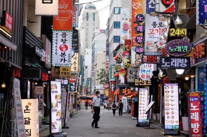 Người dân đi lại trên đường phố Seoul (Hàn Quốc). Ảnh:&nbsp;Reuters