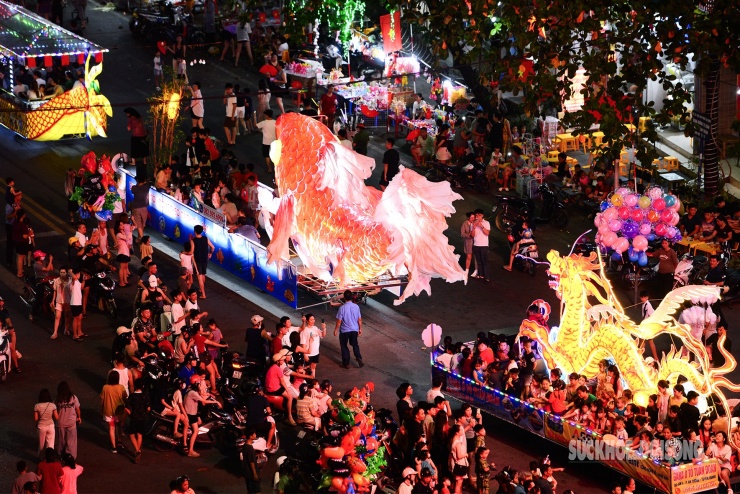 Góc nhìn trên cao cho thấy đoàn mô hình cá chép và rồng khổng lồ nối dài, dòng người nô nức đổ về hai bên đường thưởng lãm.