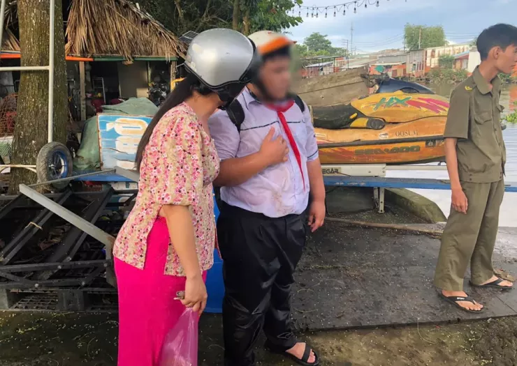 Bé trai được anh Huy, thành viên lực lượng an ninh cơ sở, cứu vào bờ an toàn. Ảnh: HT