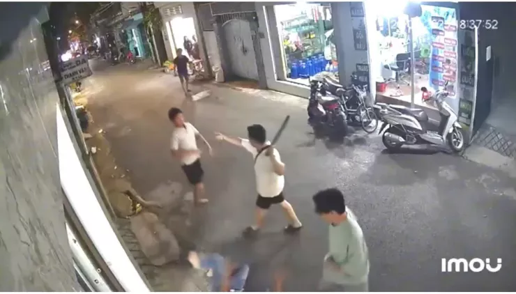 Một nam thanh niên trong nhóm cầm gậy đe dọa người dân can ngăn. Ảnh cắt từ clip