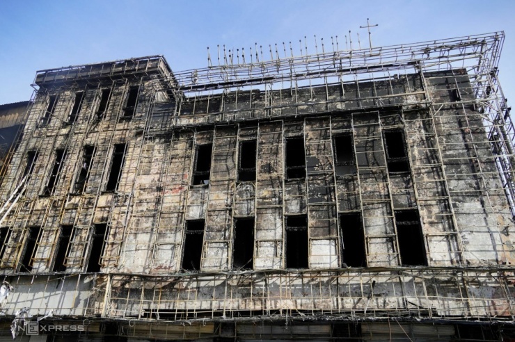 Mặt ngoài chi nhánh ngân hàng cháy đen, khung sắt cháy xém, tường bong tróc, nhiều ô kính bị vỡ.