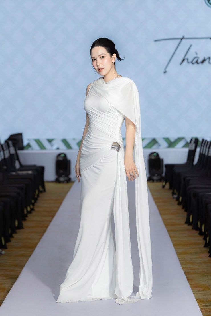 Trên sân khấu một show thời trang, nàng MC được khen duyên dáng, thanh lịch với đầm vai cape tôn đường cong, nhấn nhá tà dài mềm mại.