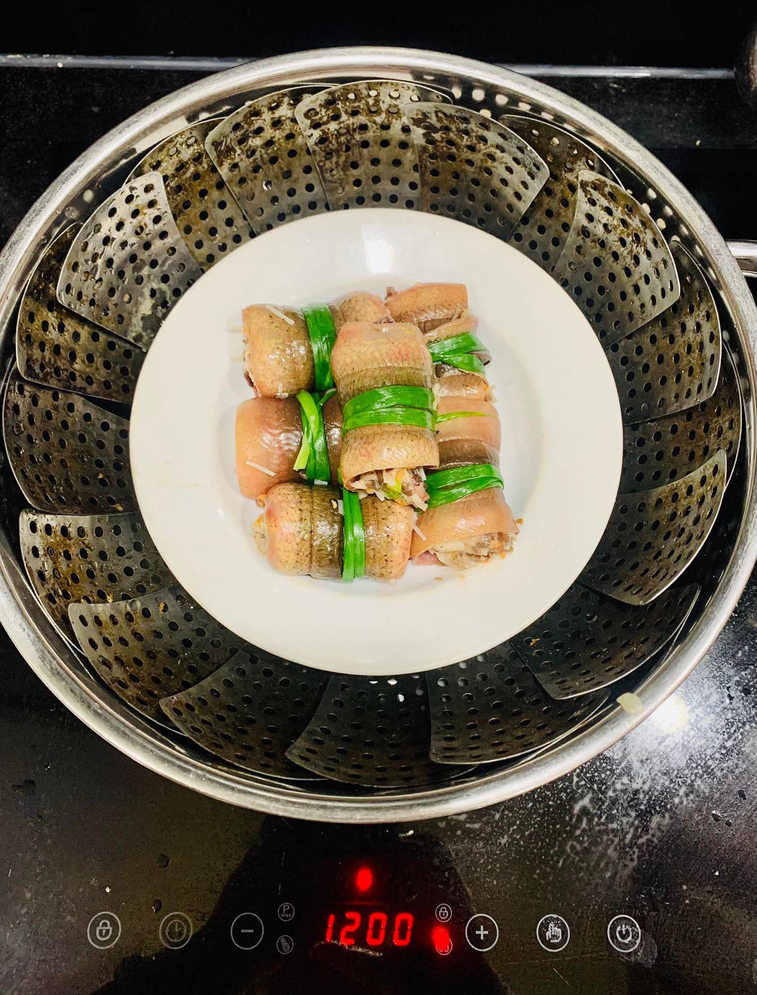 Cuộn hỗn hợp thịt vào miếng lươn đã cắt. Sau đó dùng lá hành cuộn lại để cố định.