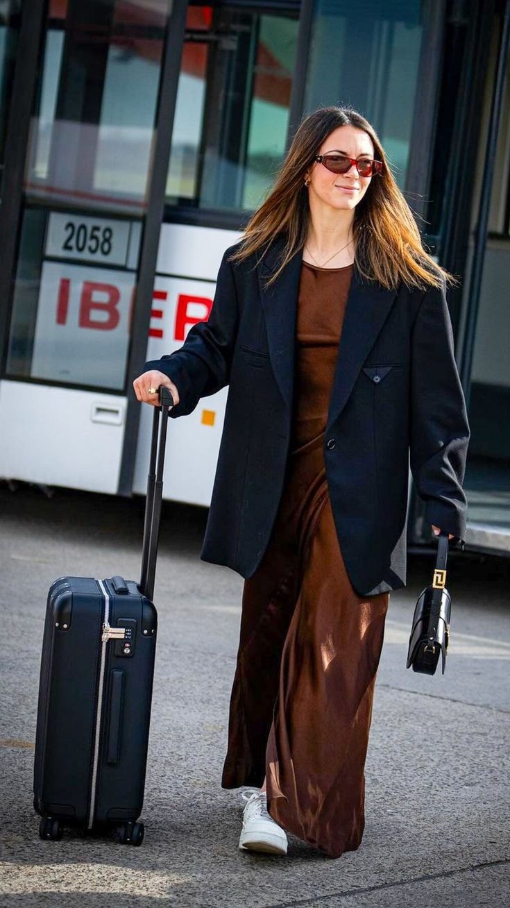 Cô tới câu lạc bộ thi đấu trong bộ cánh thoải mái gồm đầm lụa maxi, blazer và túi mini.