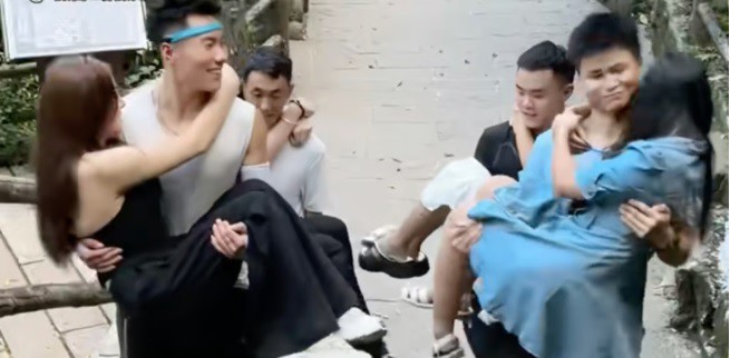Những người đàn ông trẻ, lực lưỡng được thuê làm bạn đồng hành leo núi trên núi Emei ở phía tây nam tỉnh Tứ Xuyên, nơi họ cõng những người phụ nữ lên con đường dốc ở nhiều tư thế khác nhau. Ảnh: Douyin
