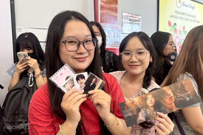Quỳnh Như (áo đỏ) và Thu Hà, 20 tuổi, dành bốn tiếng chuẩn bị trang phục, di chuyển gần một giờ từ phường Tân Mỹ đến phường Gò Vấp để kịp buổi chiếu phim lúc 15h. "Phim nào của anh tụi mình cũng xem hết, nên hôm nay phải đến bằng được", Như nói.