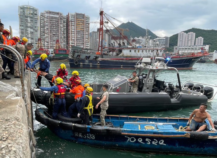 Lực lượng cứu hộ đưa người mẹ và con trai 5 tuổi khỏi hiện trường. Ảnh: SCMP.