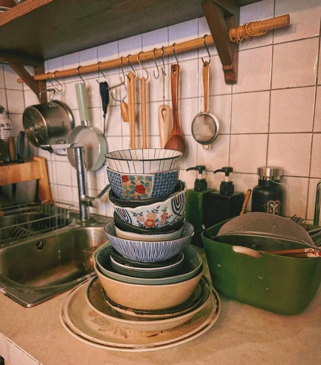 Khu vực bếp được bài trí tinh tế với đầy đủ các thiết bị cần thiết. Bàn ăn liền kề khu bếp và được bài trí thêm đèn thả.