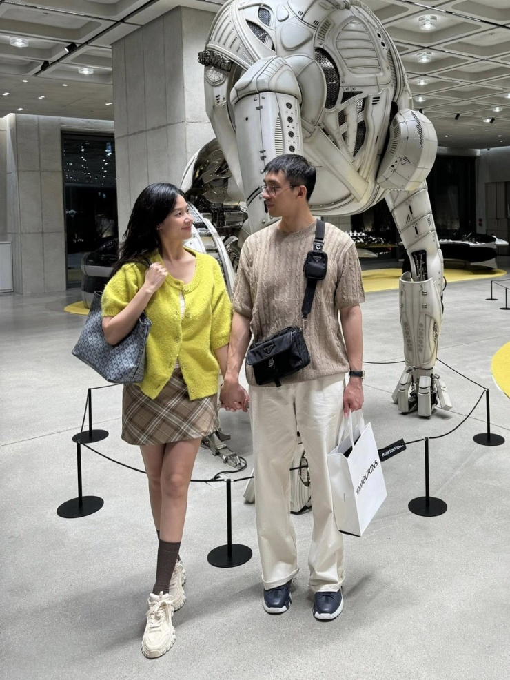 Ngày đầu tiên đến Seoul, người đẹp 36 tuổi cũng diện váy ngắn nhưng chọn màu hài hòa với trang phục bạn đời và tạo điểm nhấn bằng cardigan xanh neon.