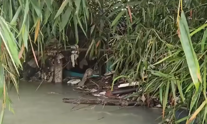 Ôtô bị nước cuốn trôi vào bụi tre dưới suối. Ảnh: Người dân cung cấp