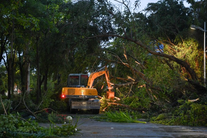 Máy xúc dọn dẹp cây cối gãy đổ trên đường phố Dương Giang, tỉnh Quảng Đông sau bão Ragasa. Ảnh: AFP