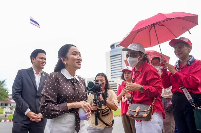 Cựu Thủ tướng Paetongtarn Shinawatra và chồng được những người ủng hộ "áo đỏ" chào đón khi họ đến Nhà tù Trung tâm Klong Prem ngày 25-9. Ảnh: Facebook/ Ing Shinawatra Forever